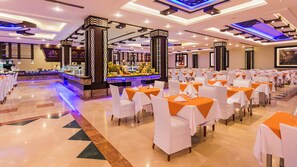 A banquet hall with rows of tables, a central bar, and a polished floor.
