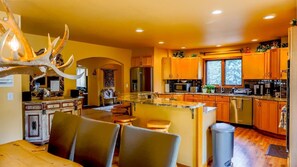 A kitchen with wooden cabinets, a granite countertop, and a central island.