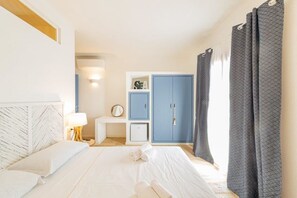 A hotel room with a bed, a desk, a wardrobe, and a bathroom.