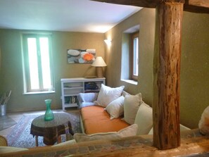 A cozy living room with a sofa, a small table, and a bookshelf.