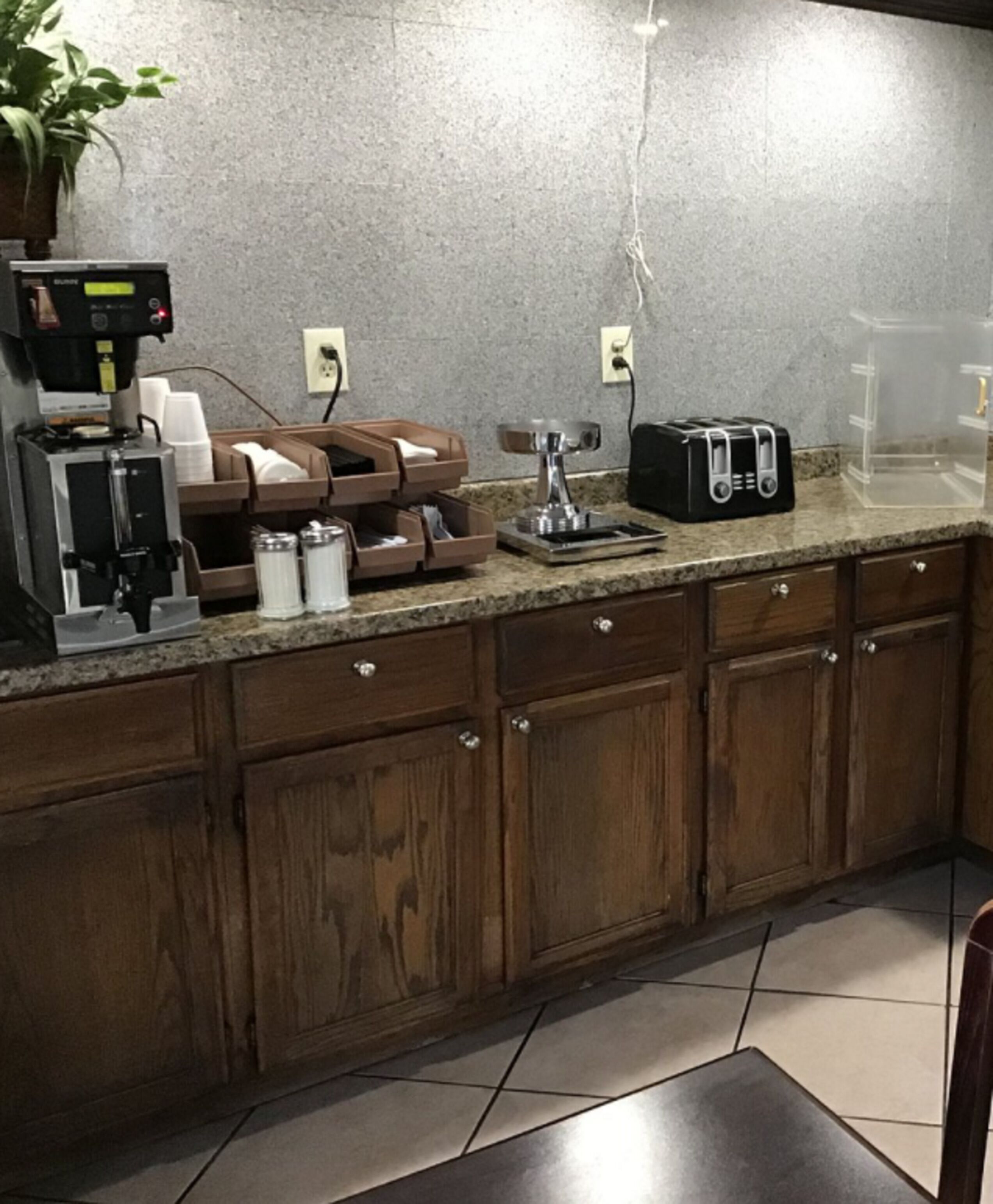 Una cocina con cafetera, tostadora y armarios.