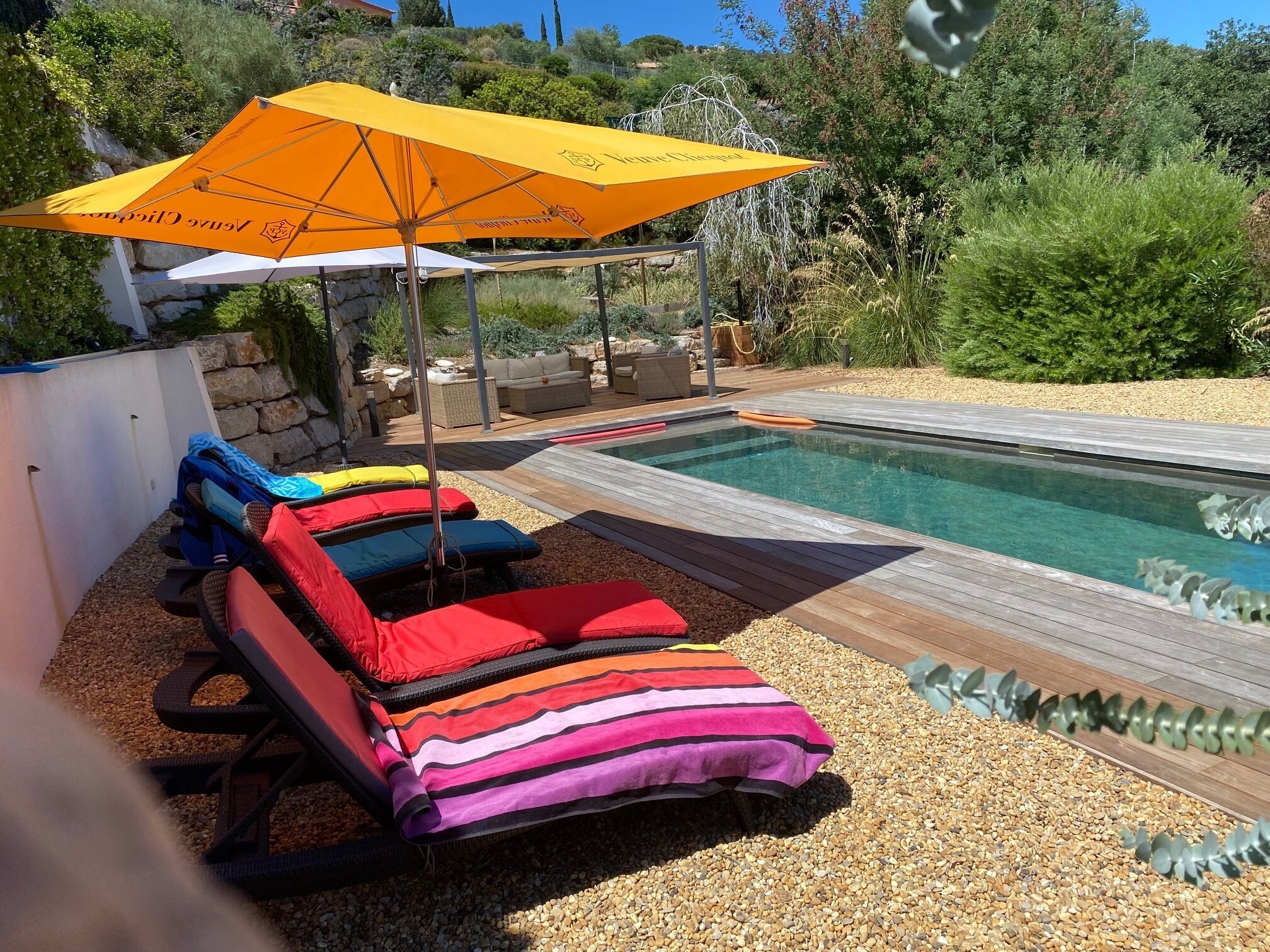 A poolside area with lounge chairs and an umbrella.