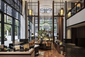 A spacious lobby with a wooden reception desk, seating area, and large windows offering views of the outdoors. - Hyatt Regency Yokohama (Yokohama)