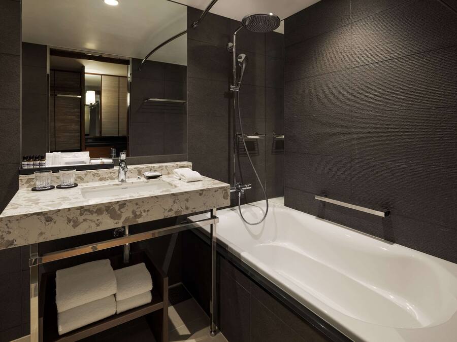 A modern bathroom with a large bathtub, a double sink vanity, and a walk-in shower.