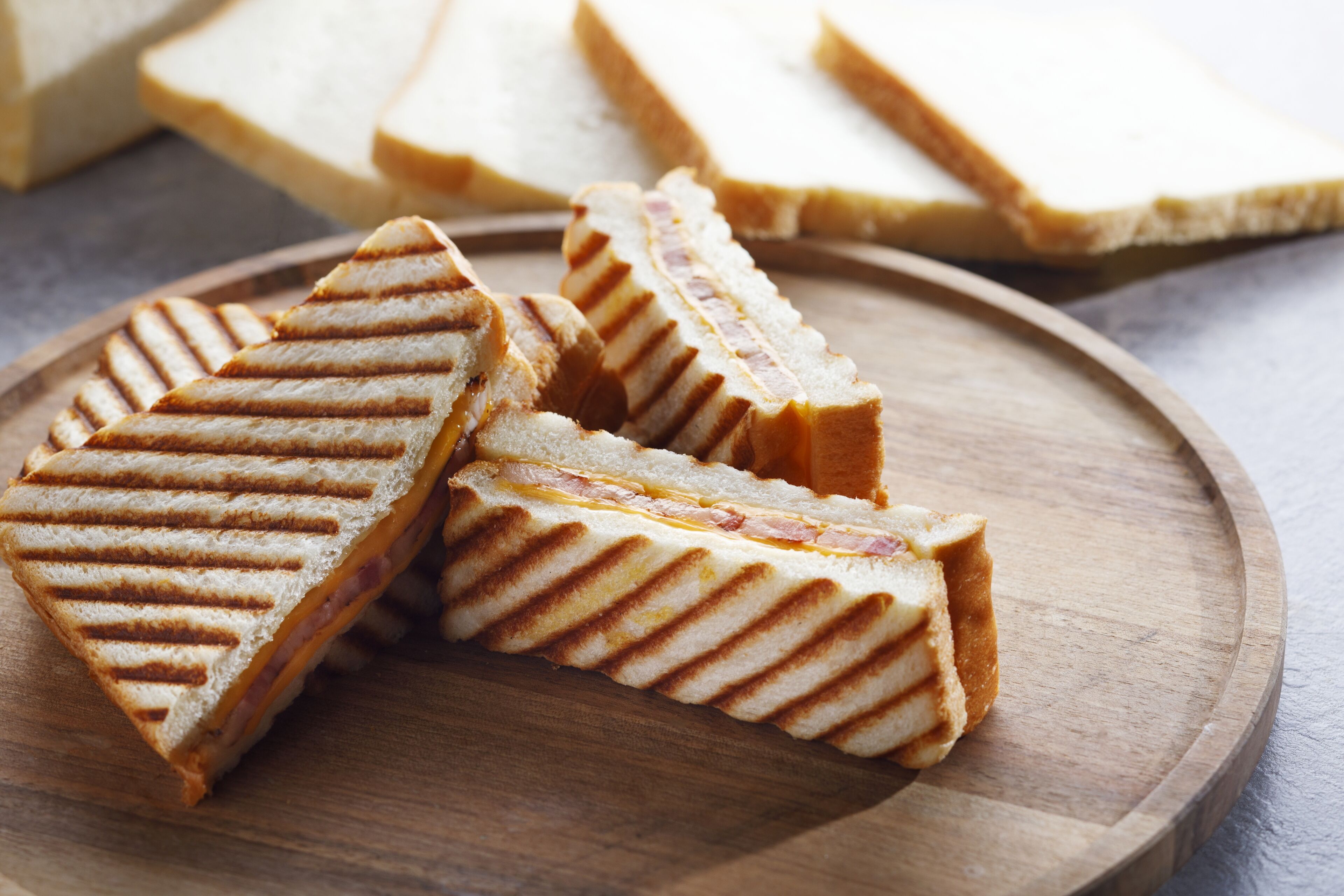 A wooden board with several triangular sandwiches.