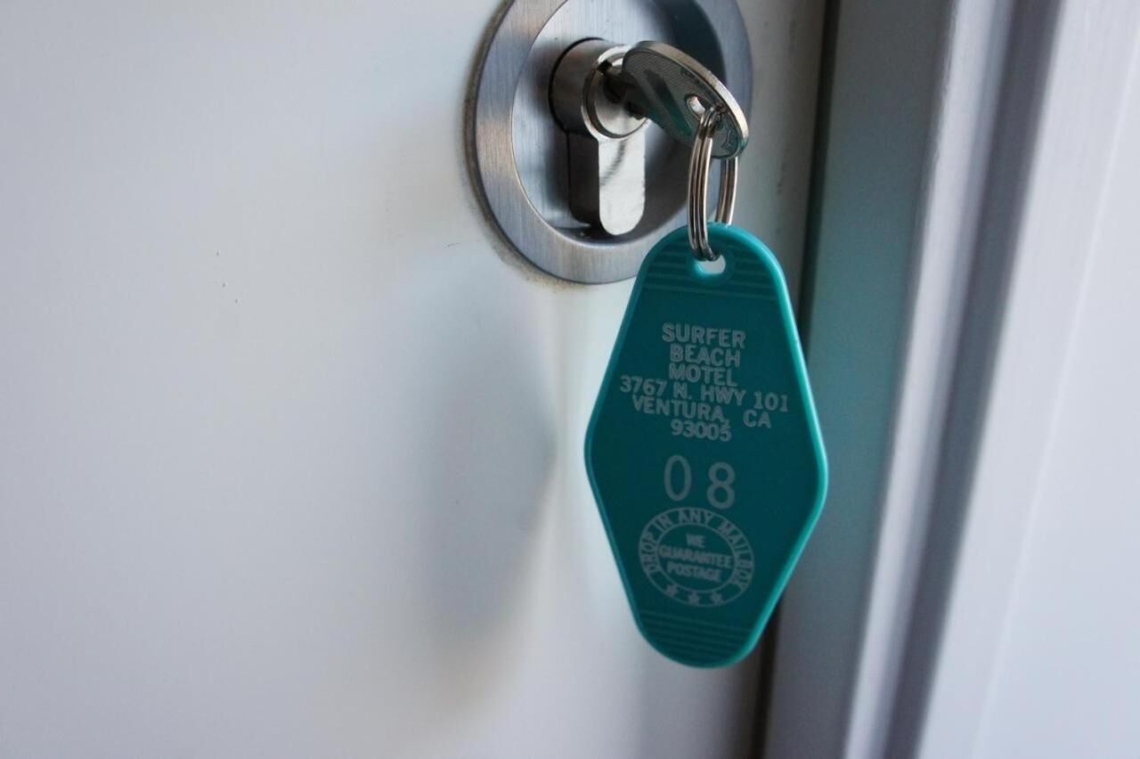 A keycard with the text "SURFER BEACH MOTEL 3767 N. HWY 101 VENTURA CA 93005" and a number "08".
