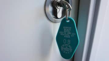 Una llave de motel con la inscripción "SURFER BEACH MOTEL 3767 N. HWY 101 VENTURA CA 93005" y el número "08".