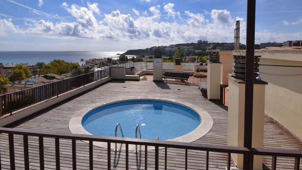 Ein Pool auf dem Dach mit Blick auf das Meer und die Stadtlandschaft.