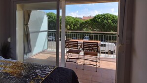 Ein Balkon mit einem Bett, einem Tisch und zwei Stühlen.
