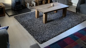 Tunnelmallinen olohuone, jossa on takka, sohvapöytä ja sohva.