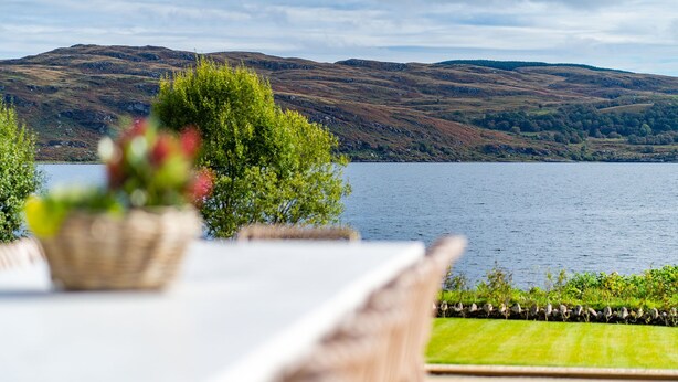 Un comedor con vistas a un lago y colinas.