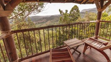 A wooden deck with a view of a mountainous landscape.