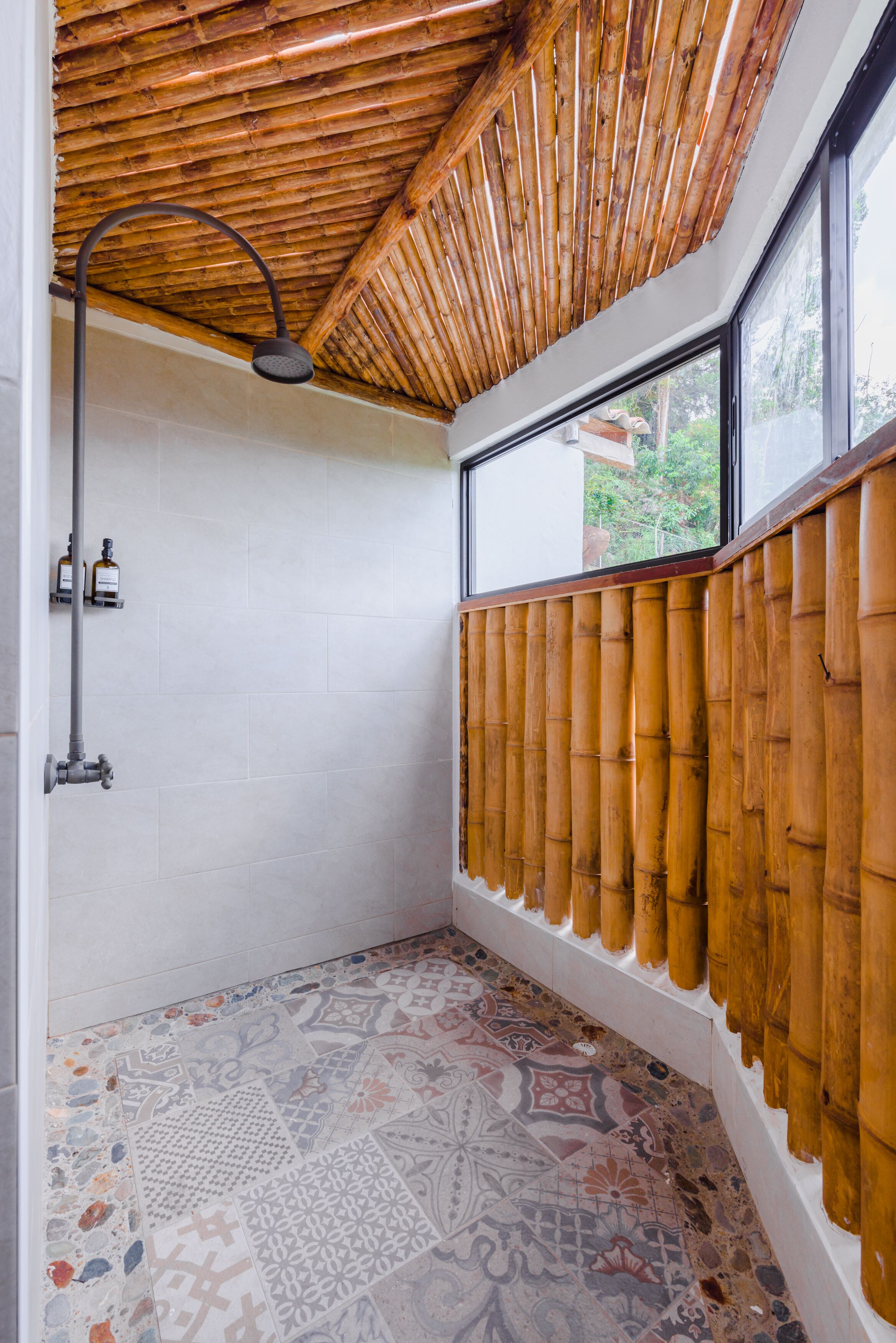 Een badkamer met een bamboe plafond, een douche en decoratieve tegels.