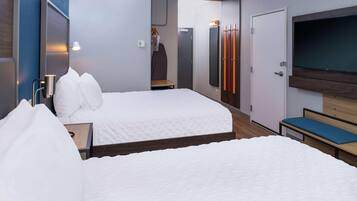 Camera d'albergo con due letti, televisione, armadio e specchio.