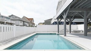 A swimming pool with a white fence and a covered area with chairs. - 5 Bedroom Oceanview House with a Private Pool! Stingray (Surfside Beach)