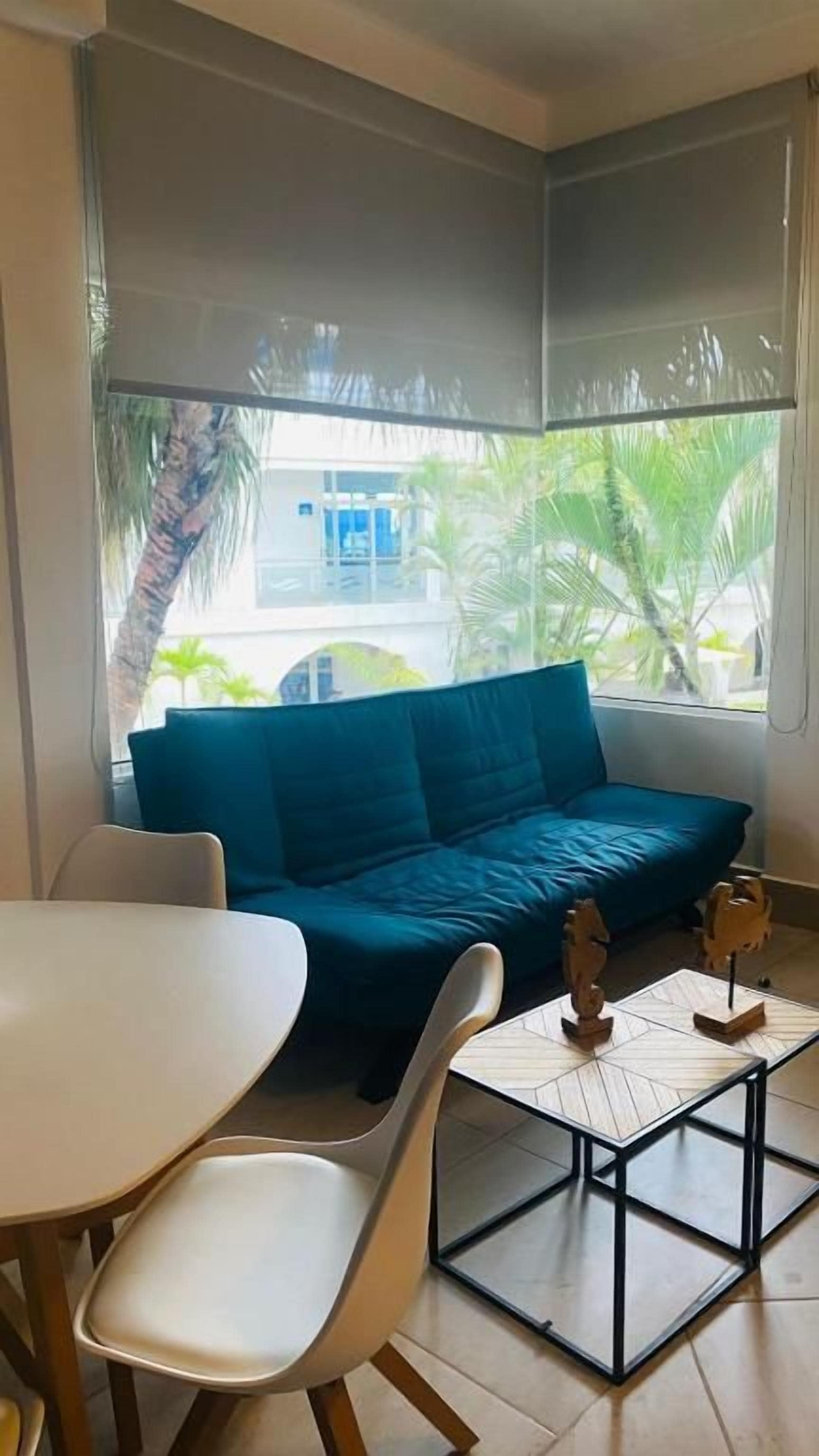 A room with a blue sofa, a small table, and chairs.