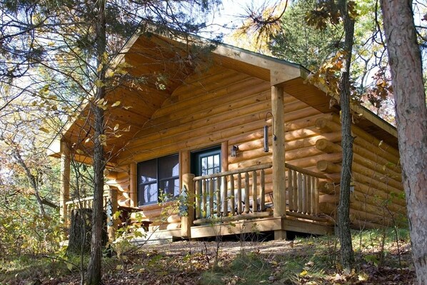 A log cabin with a porch, large windows, and a railing. - Private cabin w/jacuzzi tub, gas fireplace close to several famous parks (Reedsburg)