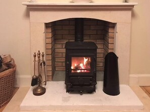 Una chimenea con un revestimiento de ladrillo y un estufa de leña negra.