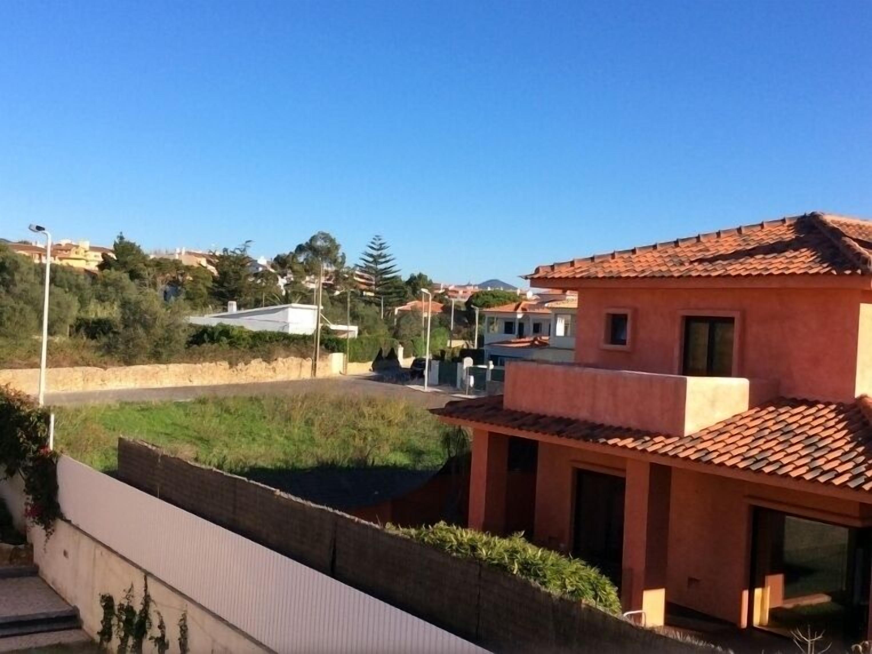 A residential area with houses, a clear sky, and a road.