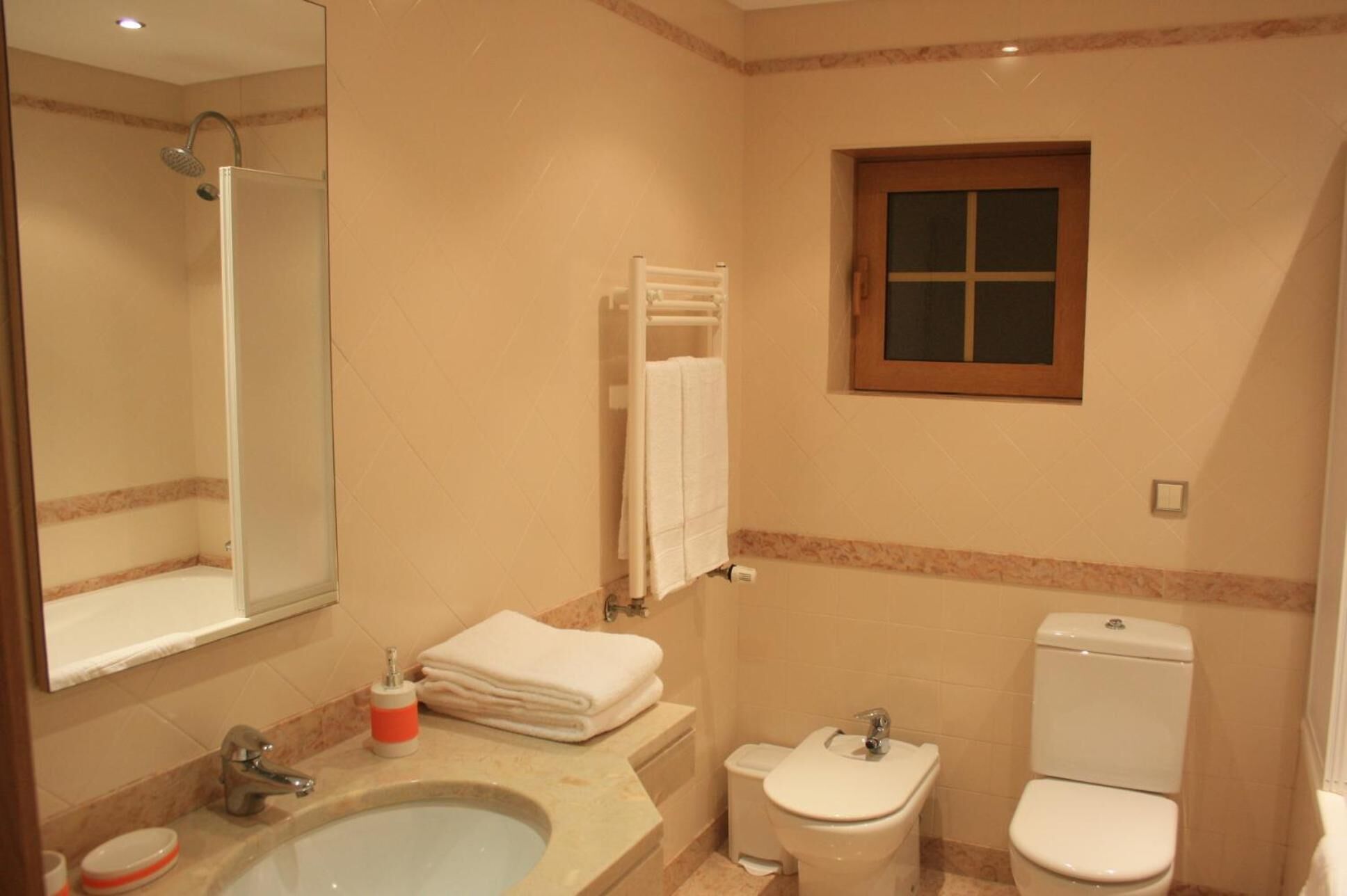 Un baño con lavamanos, inodoro y ducha.