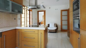 Una cocina moderna con armarios de madera, una isla central y electrodomésticos integrados.
