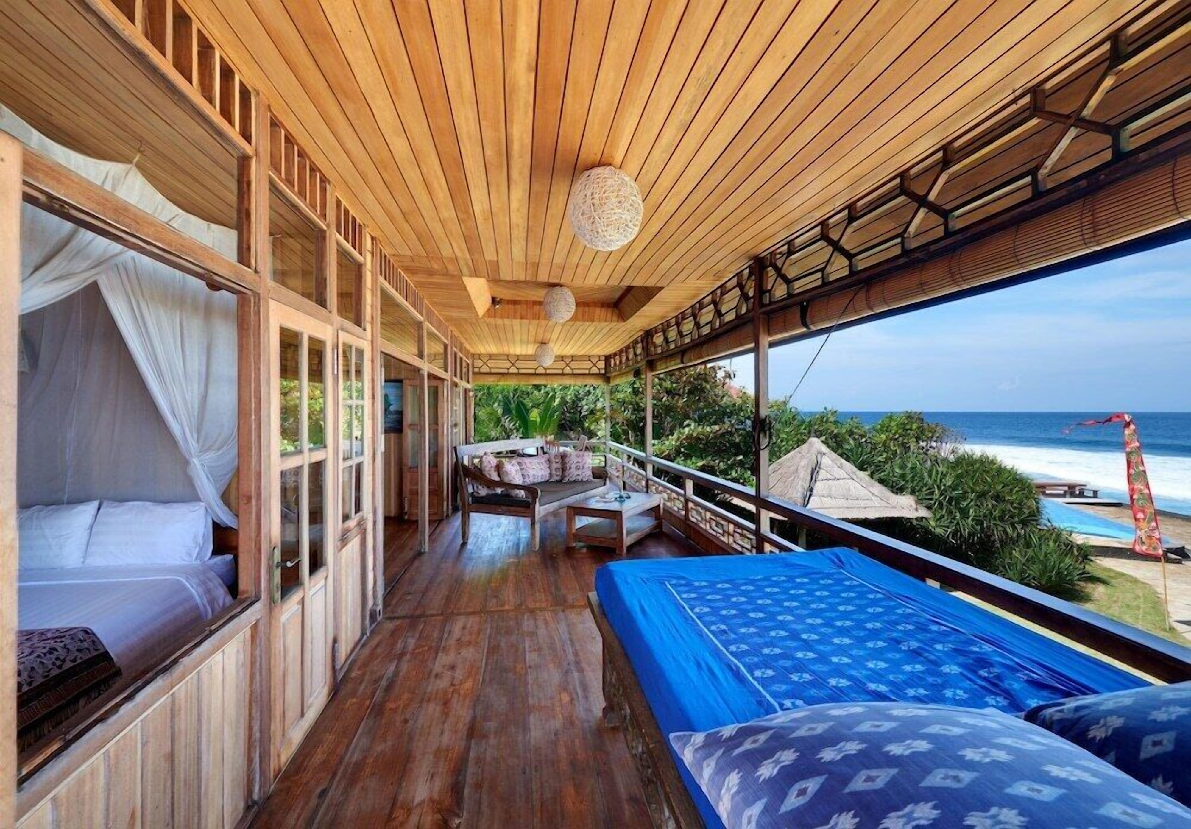 A wooden deck with a bed, a sofa, and a table.