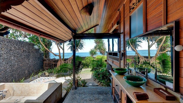 A bathroom with a stone sink, wooden vanity, and a view of the ocean. - Jasri Bay Hideaway (Karangasem)