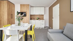 A modern apartment with a dining area, kitchen, and living space. - Villa Alpina (Szklarska Poreba)
