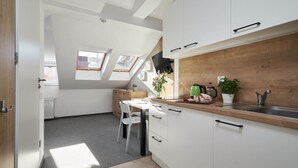 A modern kitchen with white cabinets, a wooden countertop, and skylights. - Villa Alpina (Szklarska Poreba)