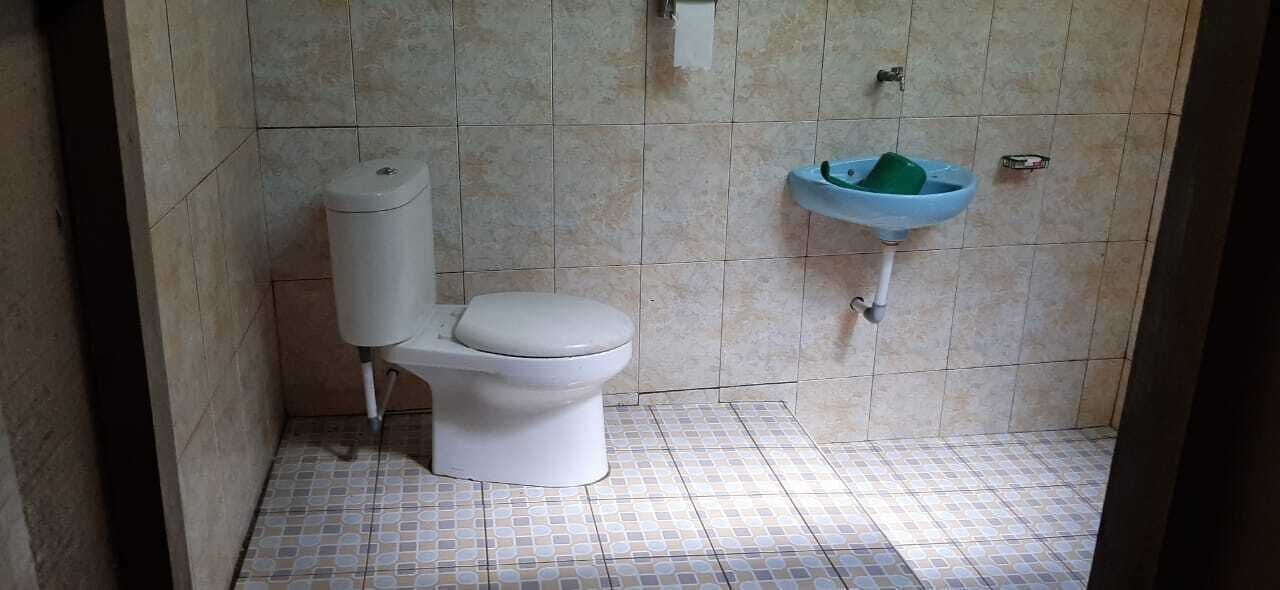 A bathroom with a toilet, a sink, and a tiled floor.