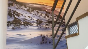 Eine Treppe mit einem Wandgemälde einer verschneiten Berglandschaft.
