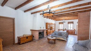 Ein Wohnzimmer mit Kamin, Holzkunst und einer hohen Decke mit freiliegenden Balken.