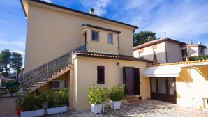 A two-story building with a tiled patio, a staircase, and potted plants. - S099 - Sirolo, new two-room apartment with wonderful sea view (Sirolo)