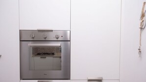 A stainless steel oven with a tiled backsplash, a built-in microwave, and a control panel with knobs and buttons. - S099 - Sirolo, new two-room apartment with wonderful sea view (Sirolo)
