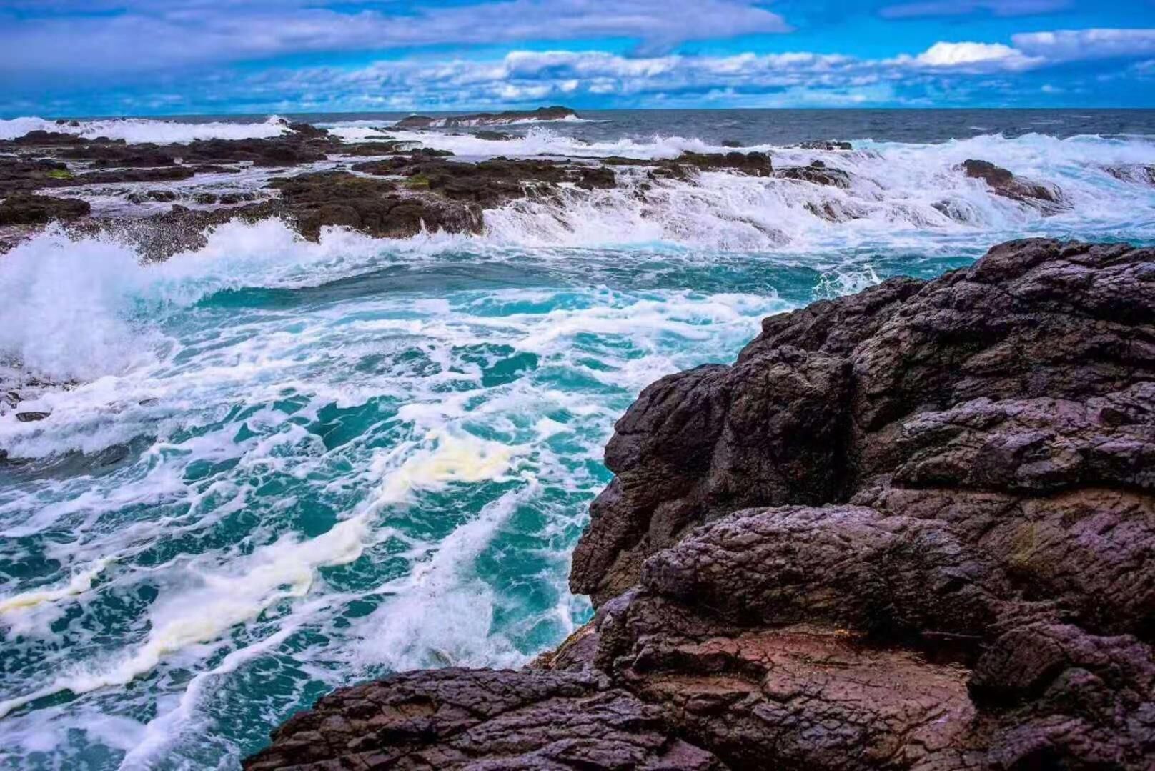A rocky coastline with turbulent ocean waves.