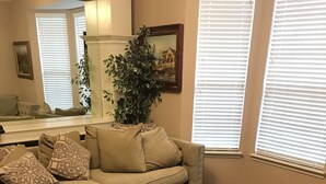 Ein Wohnzimmer mit einem beigen Sofa, einem schwarzen Couchtisch und einem gemusterten Teppich.