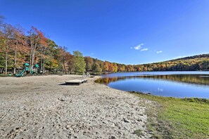 Une zone de plage sablonneuse avec une aire de jeux et un lac.