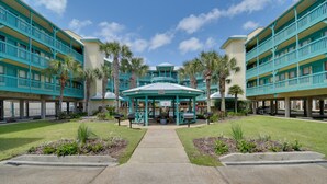 Un hotel con un gazebo centrale, diversi balconi e palme.