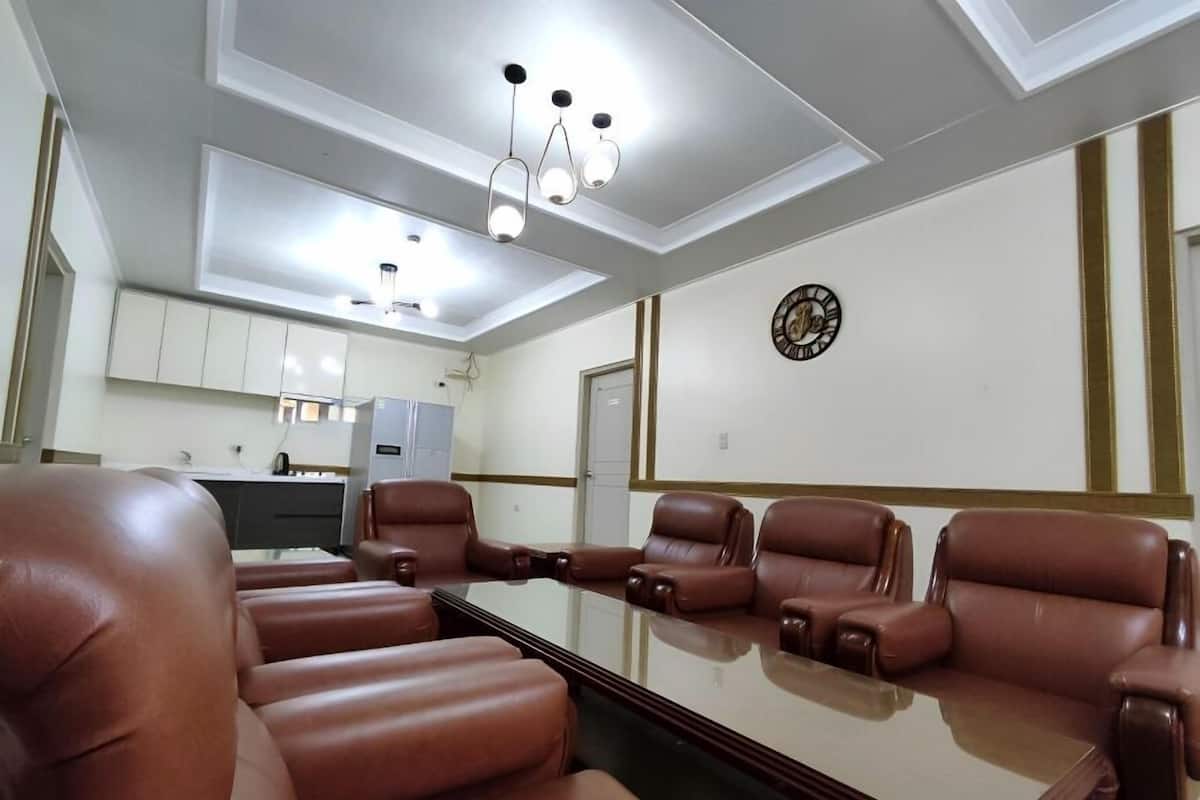 A conference room with a long table and six brown leather chairs.
