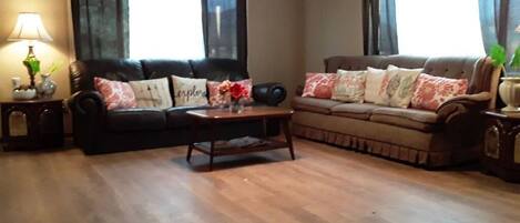 Relax in this stylish living room with two sofas, a coffee table, and a ceiling fan.