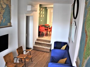 Cozy living space with a sofa, dining table, and flat-screen TV.