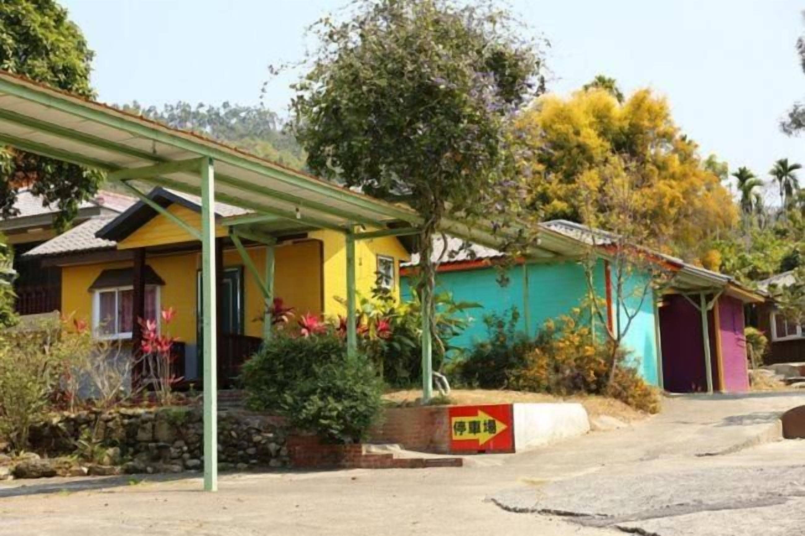 A residential area with colorful houses, a covered walkway, and a sign indicating a direction.