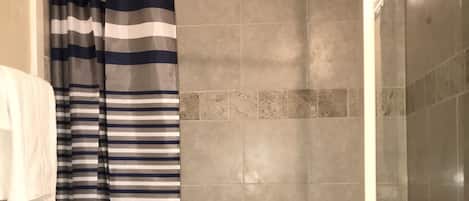 Regadera, secadora de cabello, toallas, papel de baño