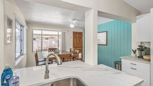 A kitchen with a white marble countertop, stainless steel sink, and a ceiling fan. - Fantastic Family/Friends Getaway - 6' deep Heated Pool & Spa close to Beaches! (Largo)