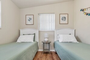 A room with two beds, a small table with a lamp, and two framed pictures on the wall. - Fantastic Family/Friends Getaway - 6' deep Heated Pool & Spa close to Beaches! (Largo)
