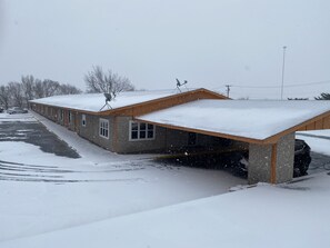 Un bâtiment doté d’un espace de stationnement couvert et dont le toit est recouvert de neige.