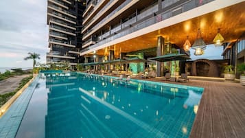 Un hôtel moderne doté d’une piscine à débordement sur le toit, d’un espace extérieur aménagé et offrant une vue sur l’océan.