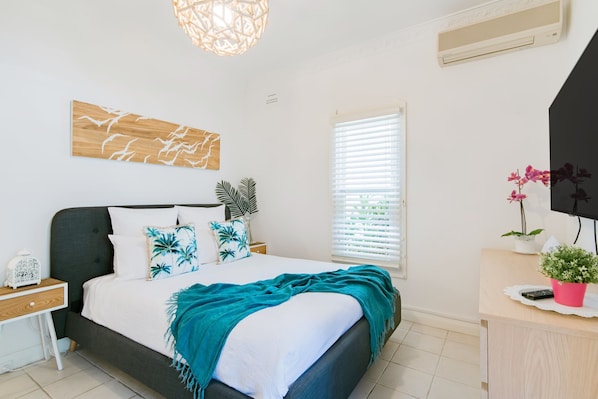 Une chambre à coucher comprenant un lit, une table de chevet, une commode et un bureau avec une chaise.