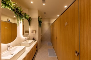 A modern bathroom with wooden cabinets, a large mirror, and a sink. - CHO Stay Capsule Hotel - Taoyuan Airport T2 (Taoyuan City)