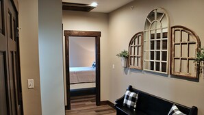 A hallway with a wooden bench, a door, and a wall with decorative window frames. - 7 BR, 7.5 Bath Home with Hot Tub close to all of the Branson Fun! (Branson)